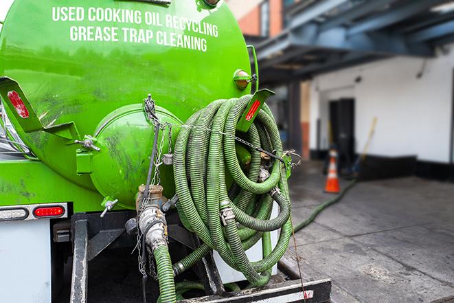 a vacuum truck pumping out a large underground grease trap in Fort Pierce, FL